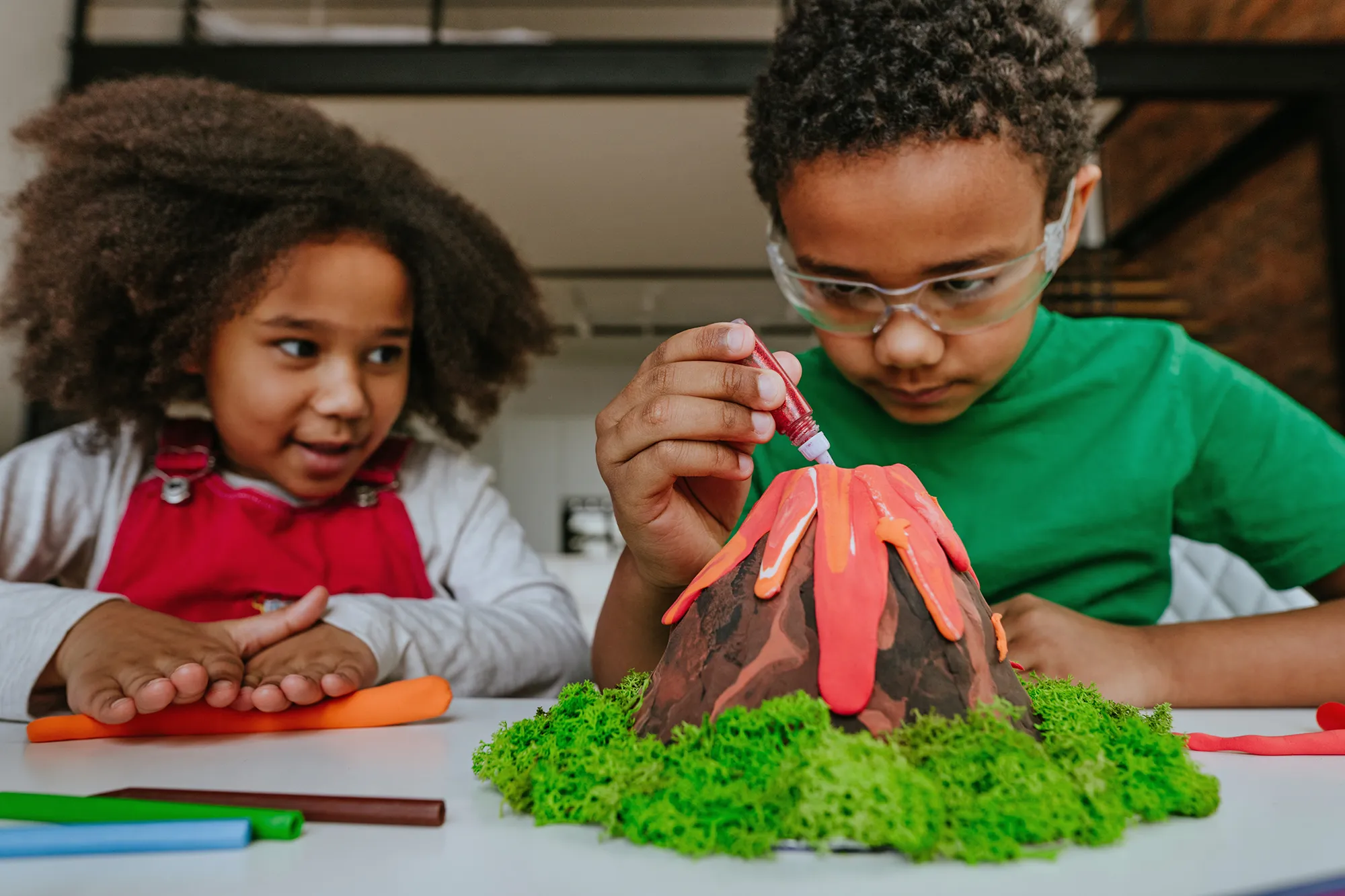 two children make a volcano