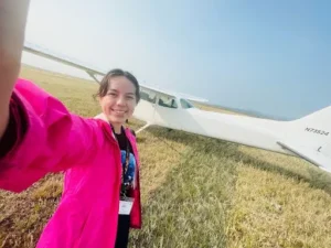girl poses in front of plane