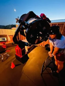 girl looks through telescope
